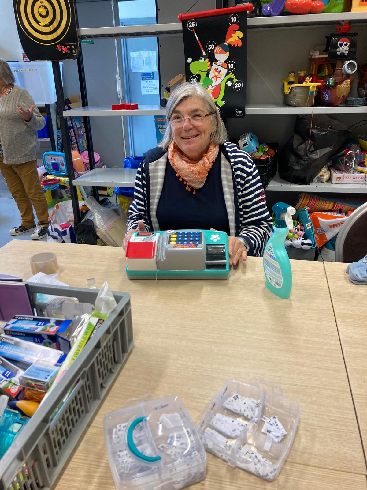 Une bénévole souriante à la boutique